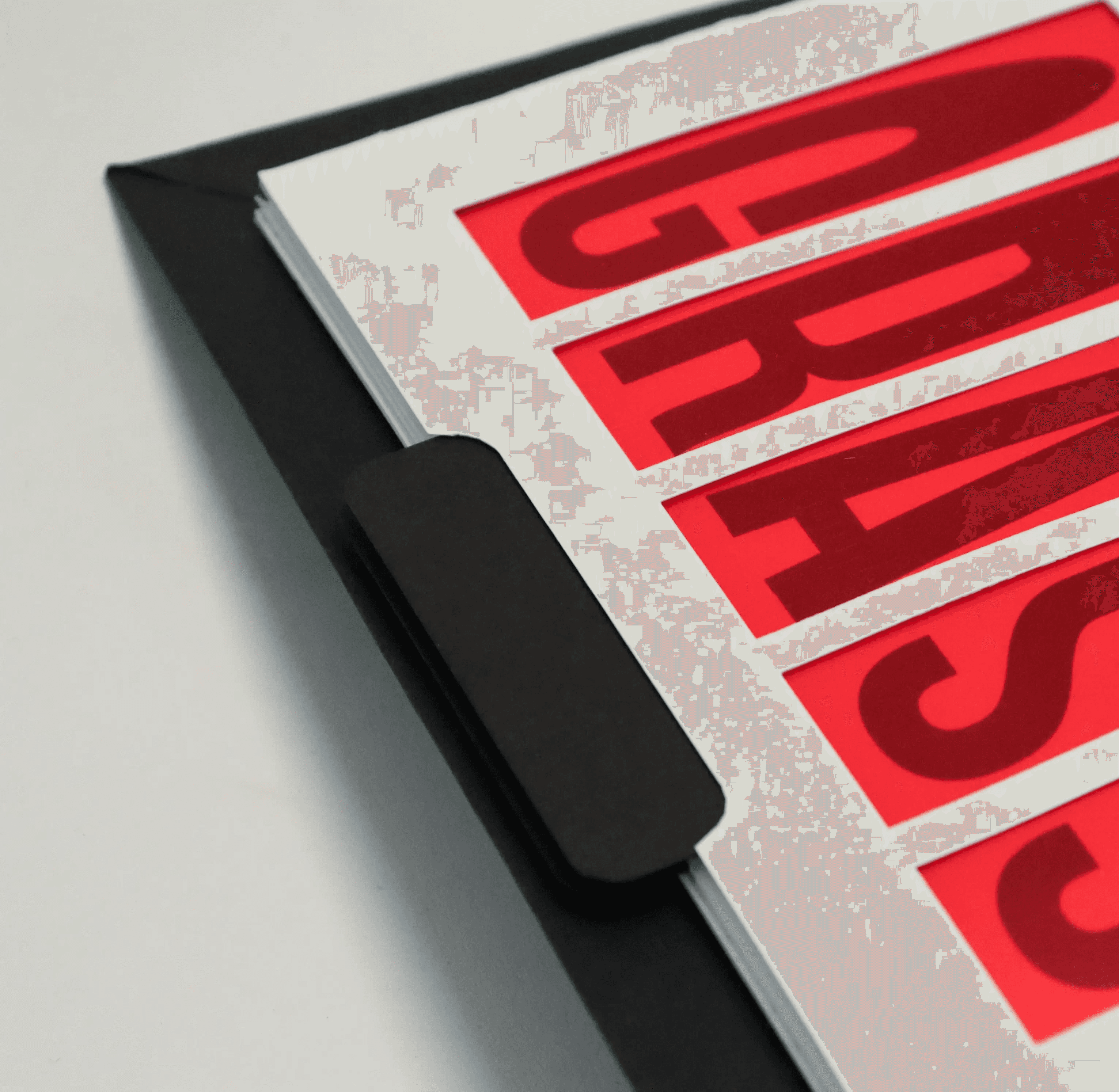 Close-up showing a rounded indent in a book page with a black slider pull-tab behind it