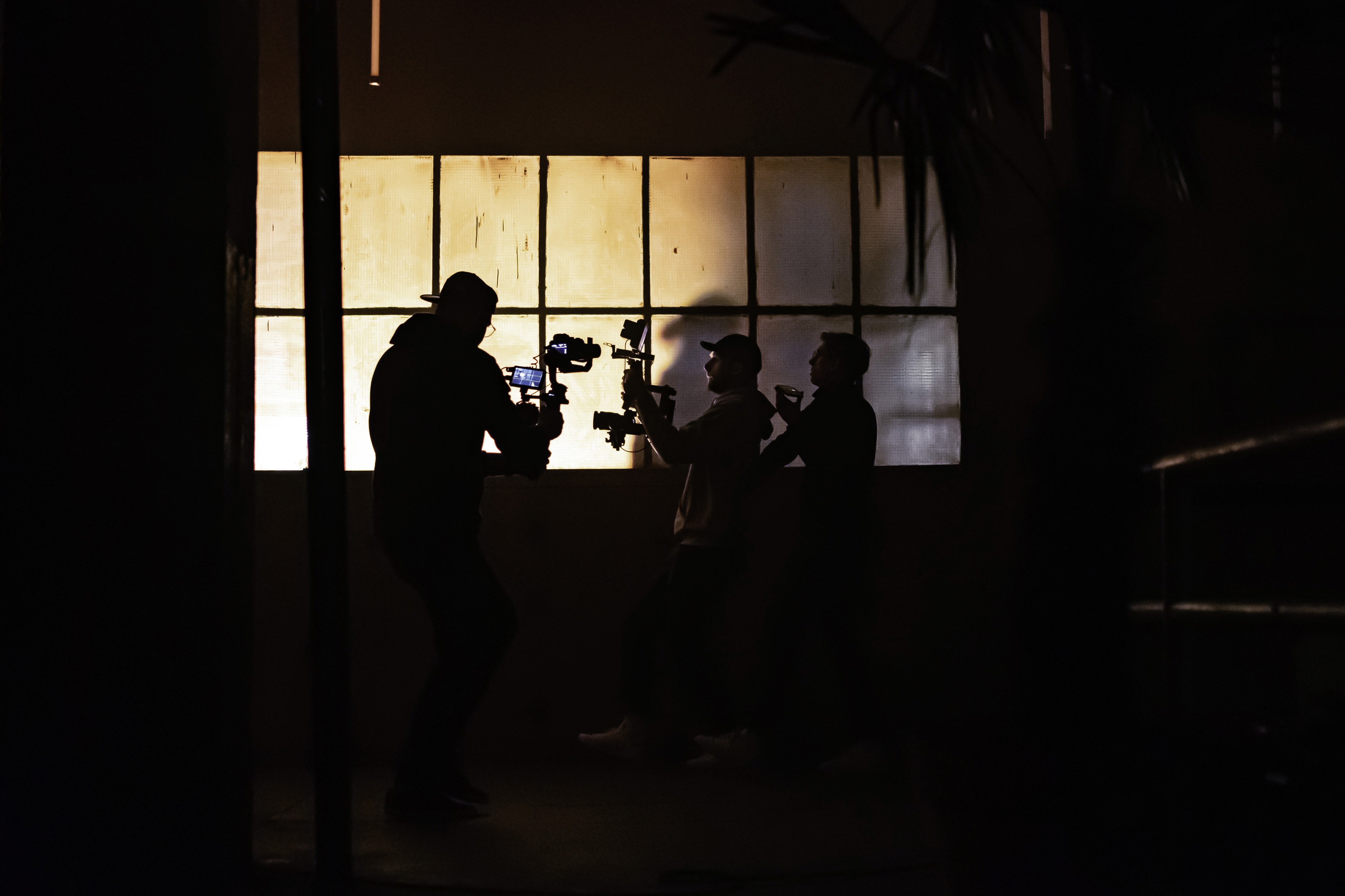 A thoughtful young person with dark hair gazes to the side, captured in soft black and white lighting.