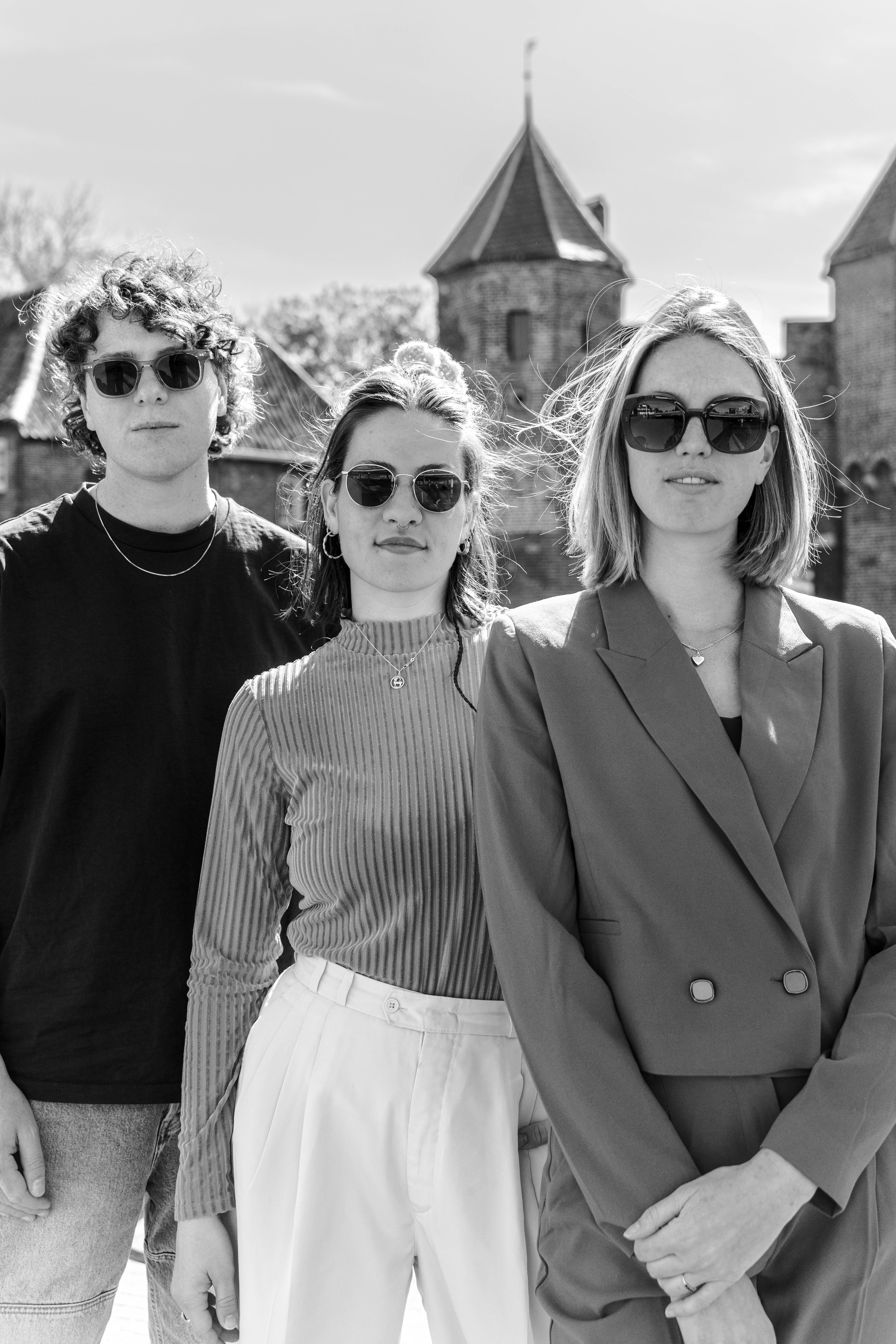 zwart wit foto van een jongen en twee meiden met brillen op