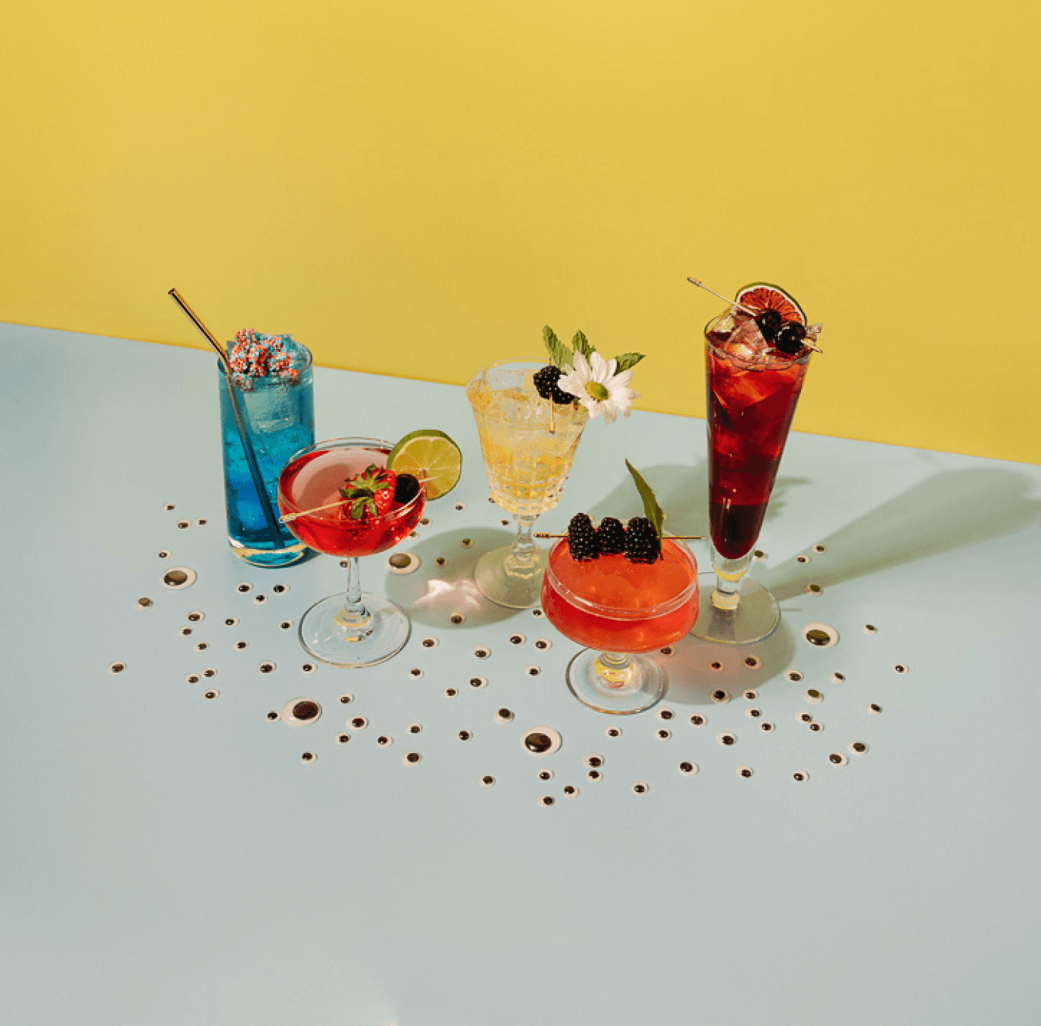 Collection of five curiously vibrant non-alcoholic drinks with googly eyes scattered around