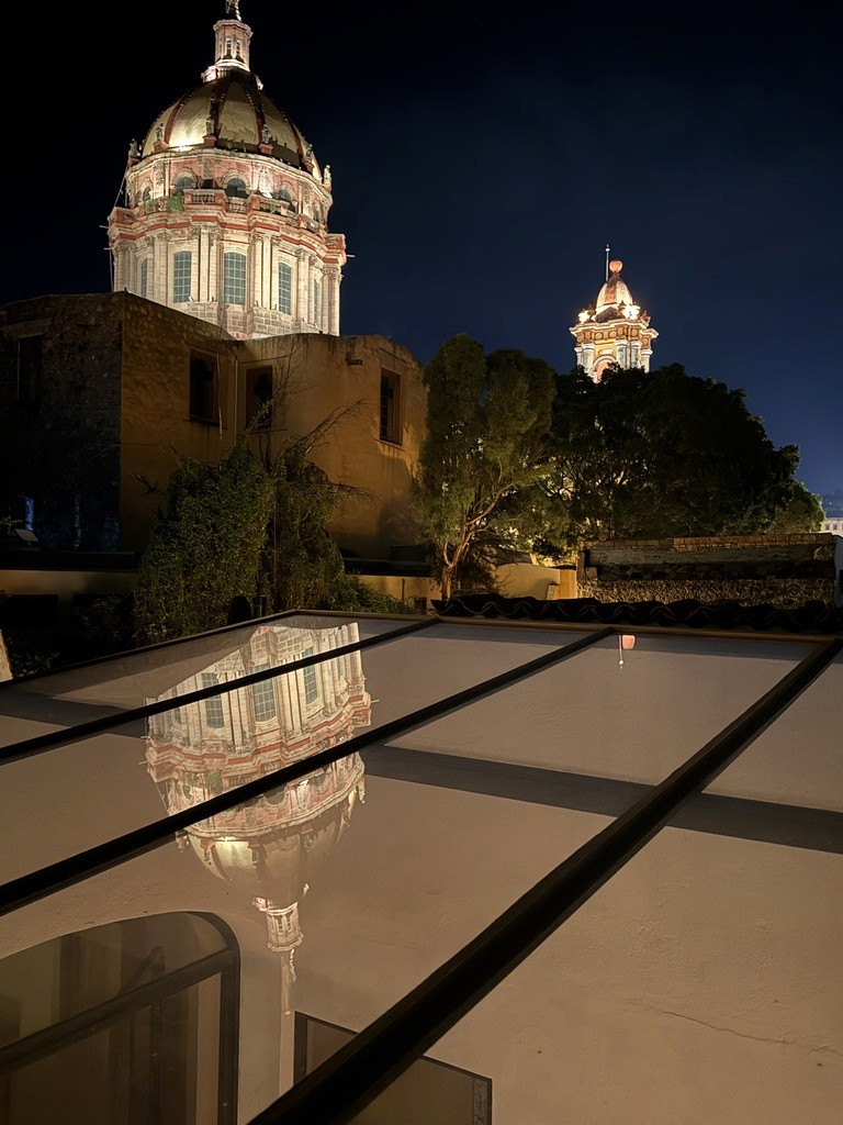 Nighttime view of the Parroquia reflected in a rooftop surface in San Miguel de Allende