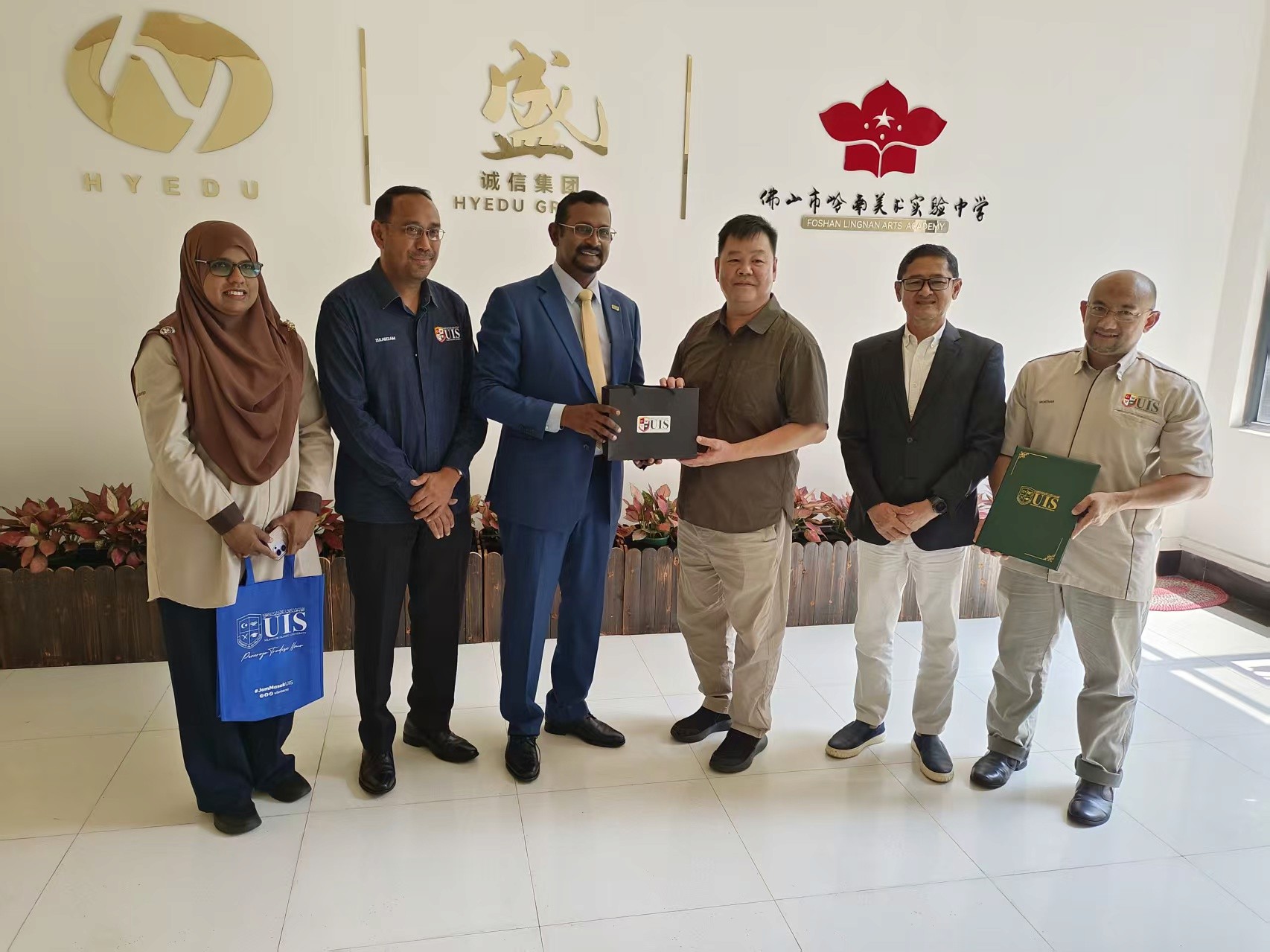 UIS and HYEDU delegations pose together at the HYEDU Foshan office following the exchange of partnership documents and gifts