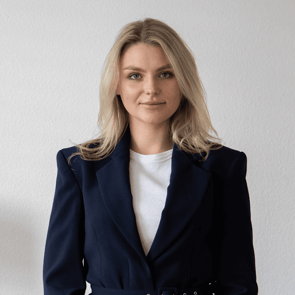 Portrait of a laughing person with curly hair wearing a white shirt