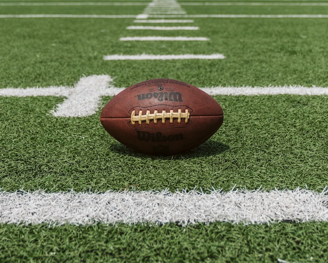 An American football resting on the field, symbolizing the legacy of the first Super Bowl and its historical significance.