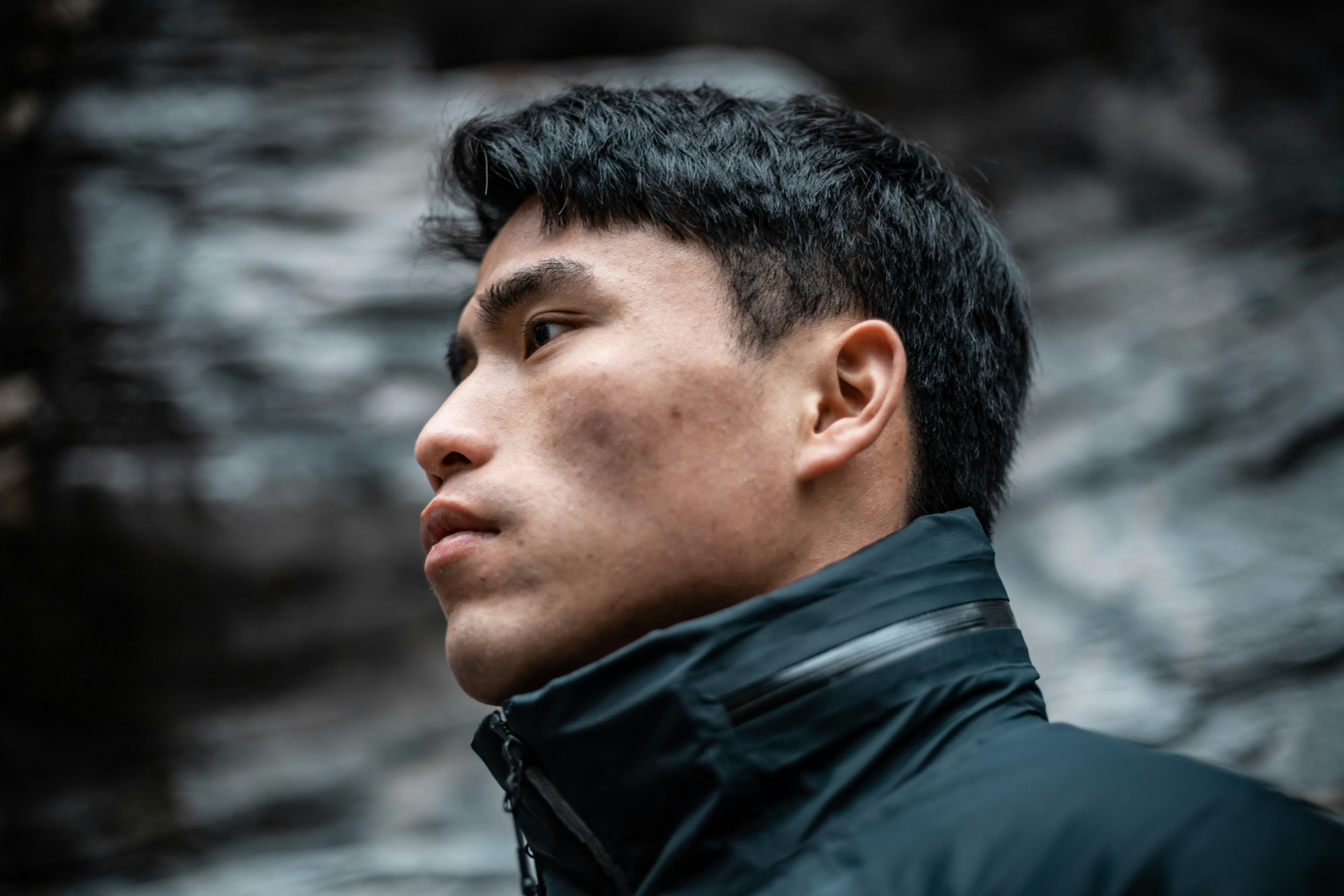 A man standing in front of a rock formation