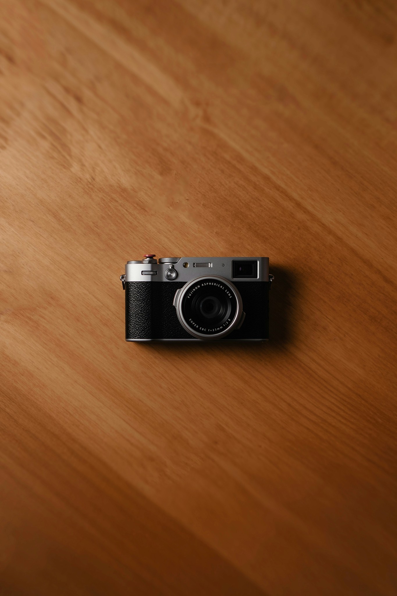 A vintage camera rests on a wooden surface.