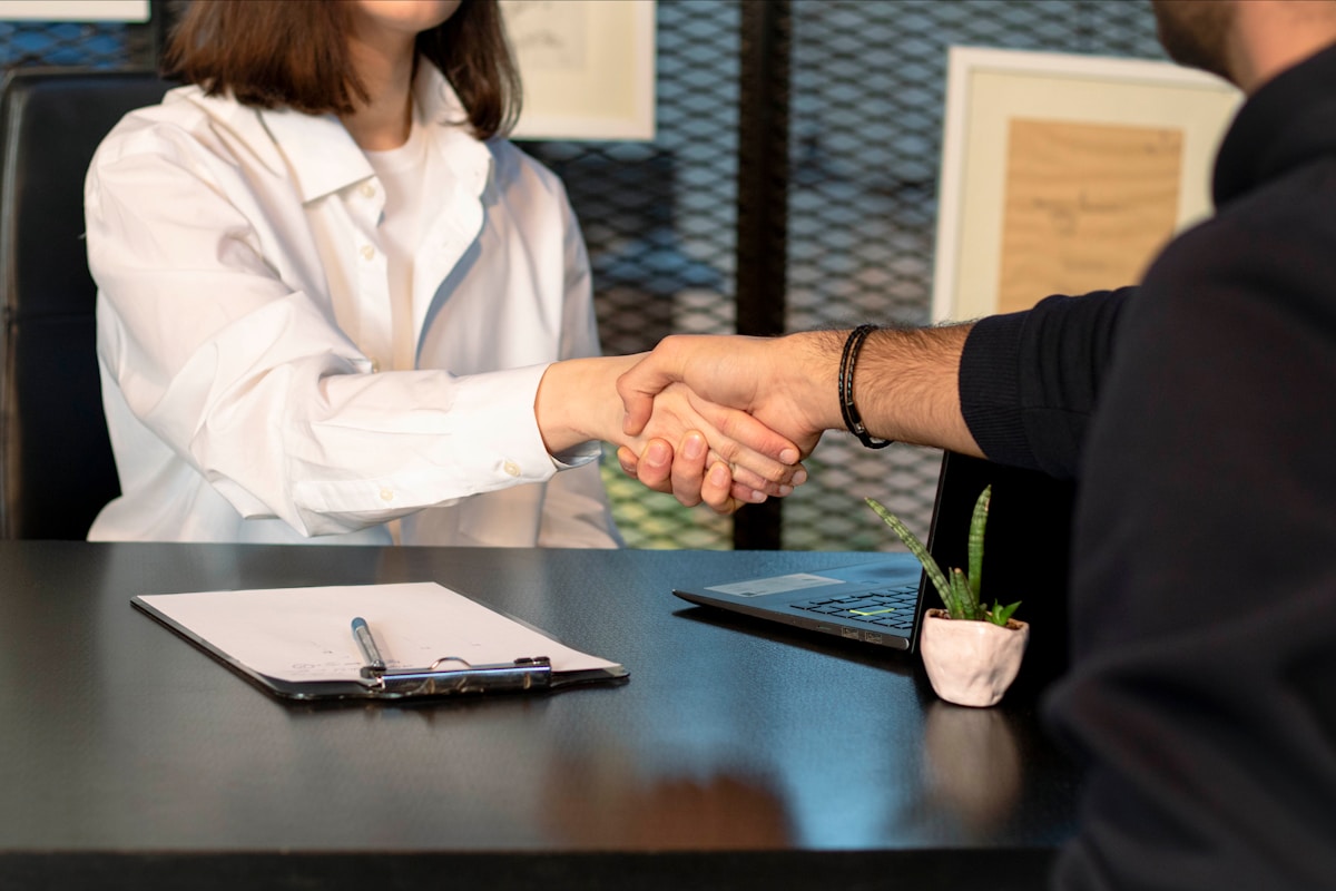 Two professionals shaking hands after a client meeting
