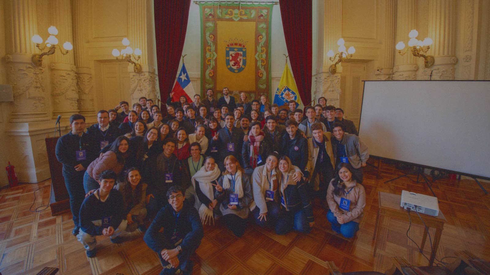 Jóvenes universitarios posan en grupo en un salón de la Municipalidad de Santiago en un evento de IdeaPaís.