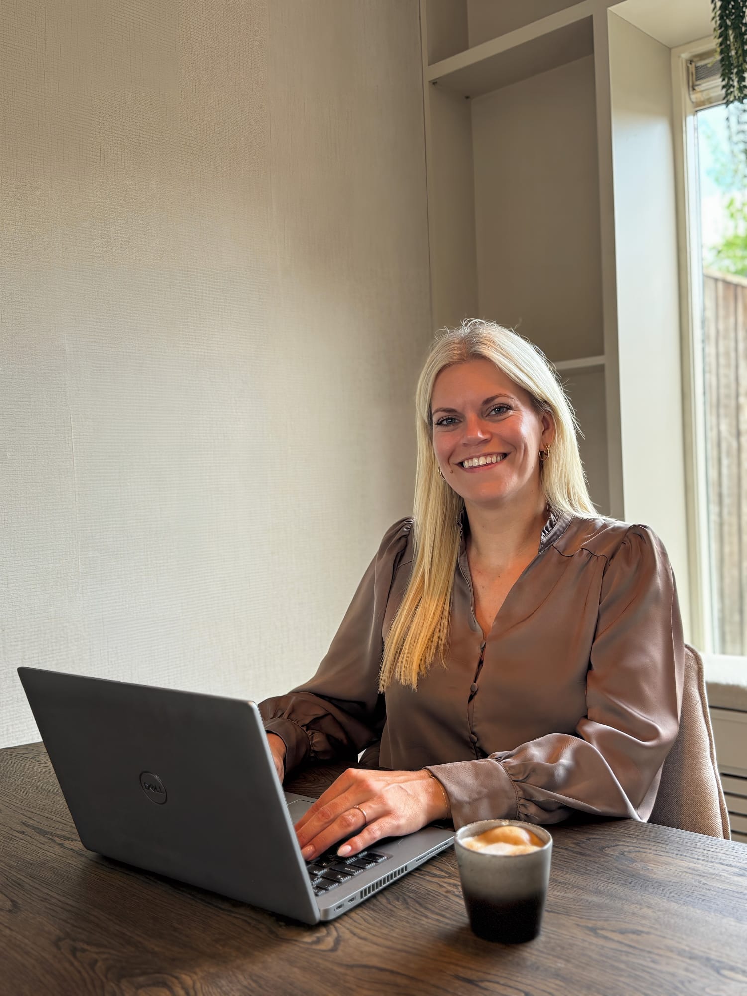 Bianca Schenkels aan tafel met Dell-laptop