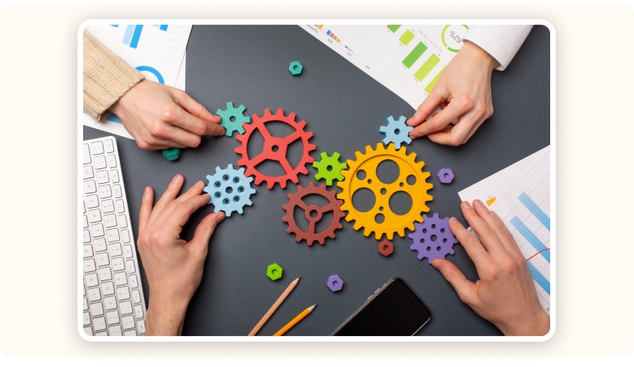 Hands assembling colorful gears