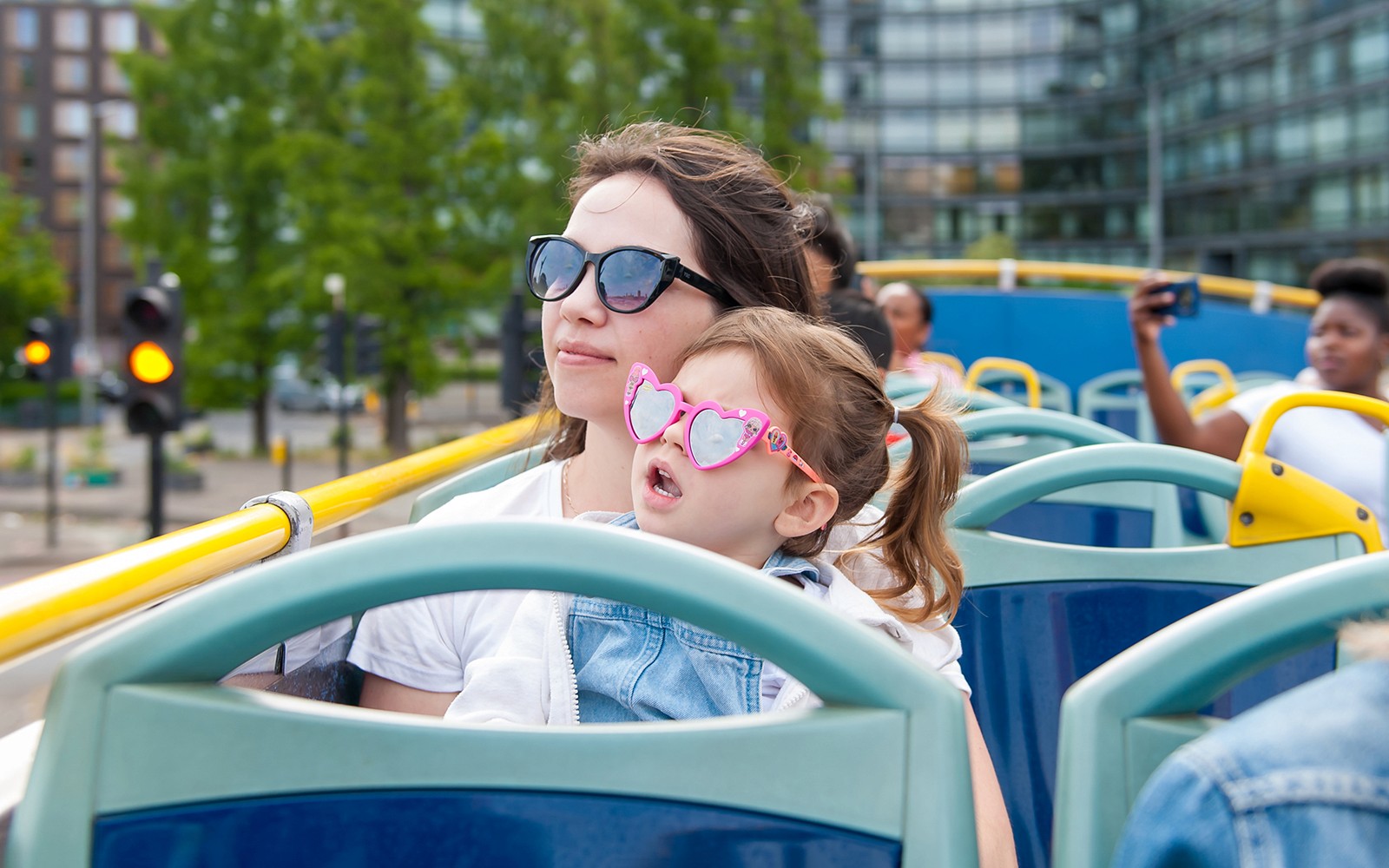 Children on a Tootbus tour in London with a live guide, passing city landmarks.