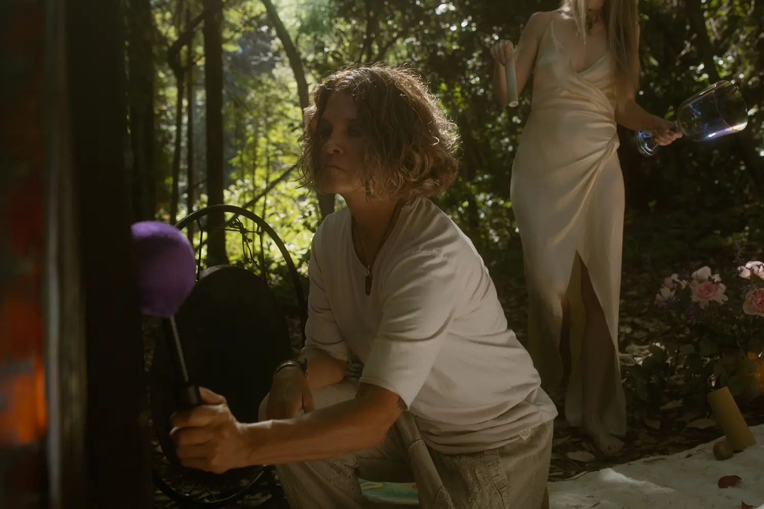 Guide performing sound healing with a gong during an outdoor group plant medicine ceremony