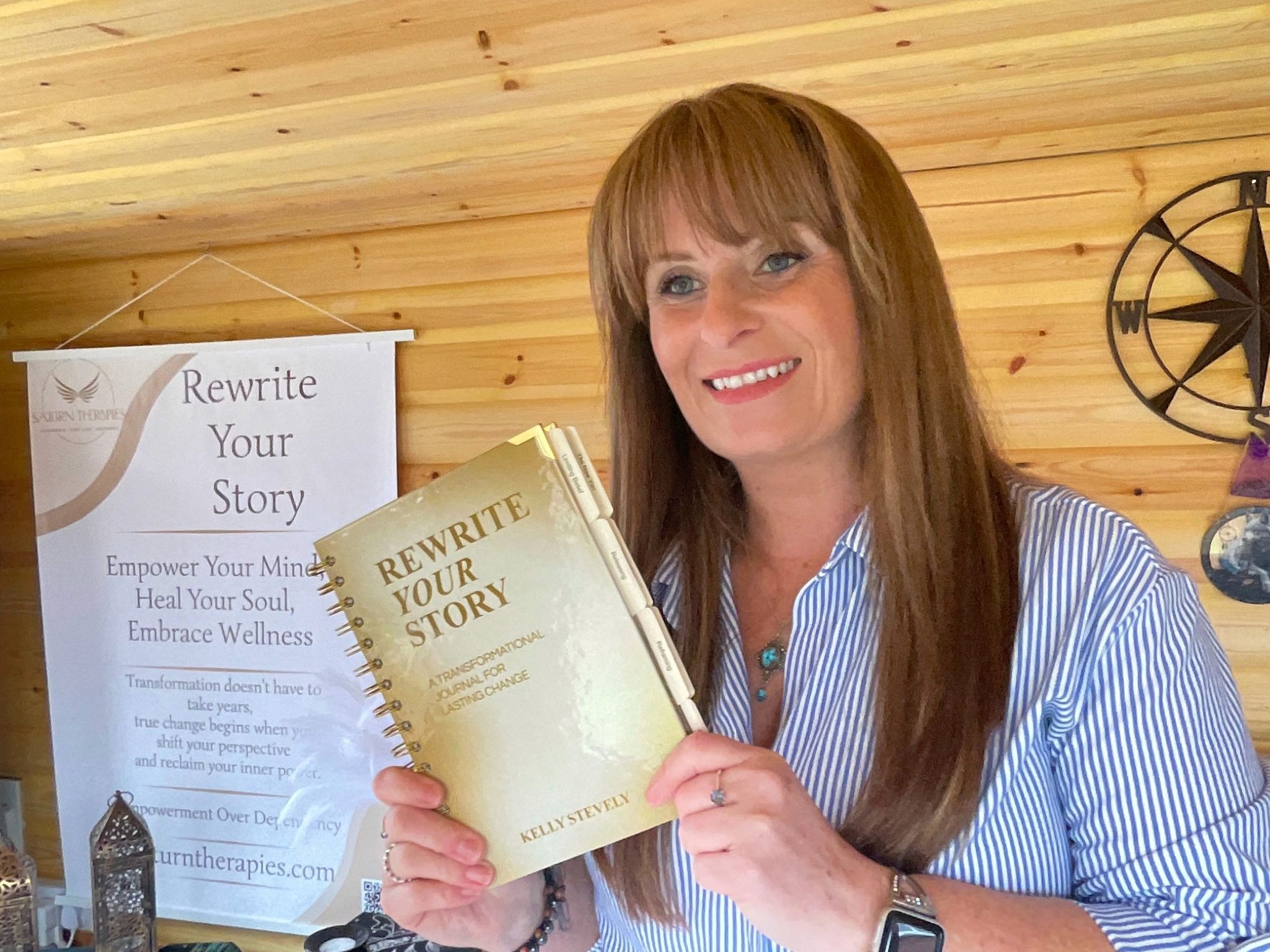 Kelly Stevely holding “Rewrite Your Story” journal beside wellness banner promoting transformational healing and personal growth.