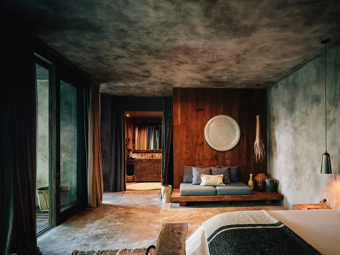 Premier Suite en Nômade Tulum con una majestuosa piscina privada que ofrece vistas al mar y hermosas palmeras, todo visible desde la terraza privada.