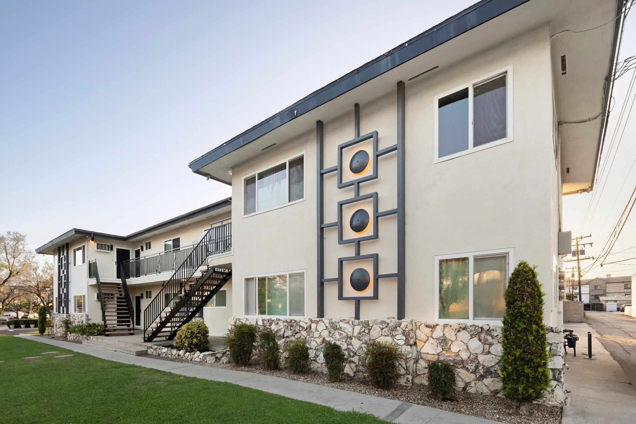 9025 Mills Avenue angled exterior showing modern facade, stone accents and green open lawn area