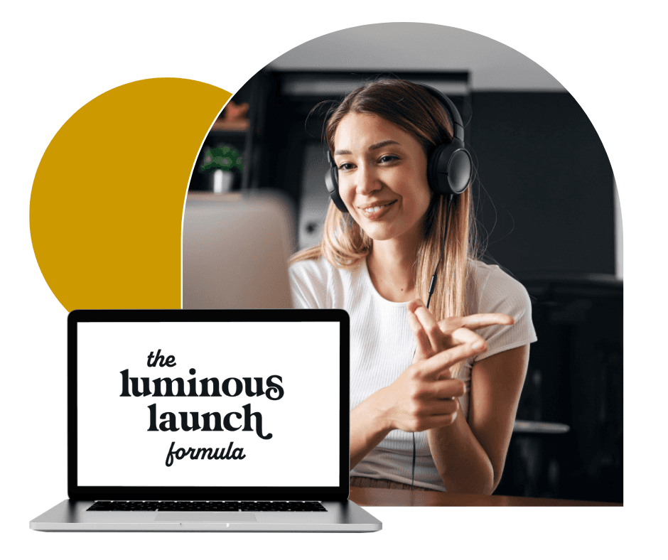 A woman wearing headphones engaged in an online webinar or video call is seated at a desk, with a laptop displaying the text "the luminous launch formula" in front of her; modern workspace elements and soft lighting add to the professional atmosphere.