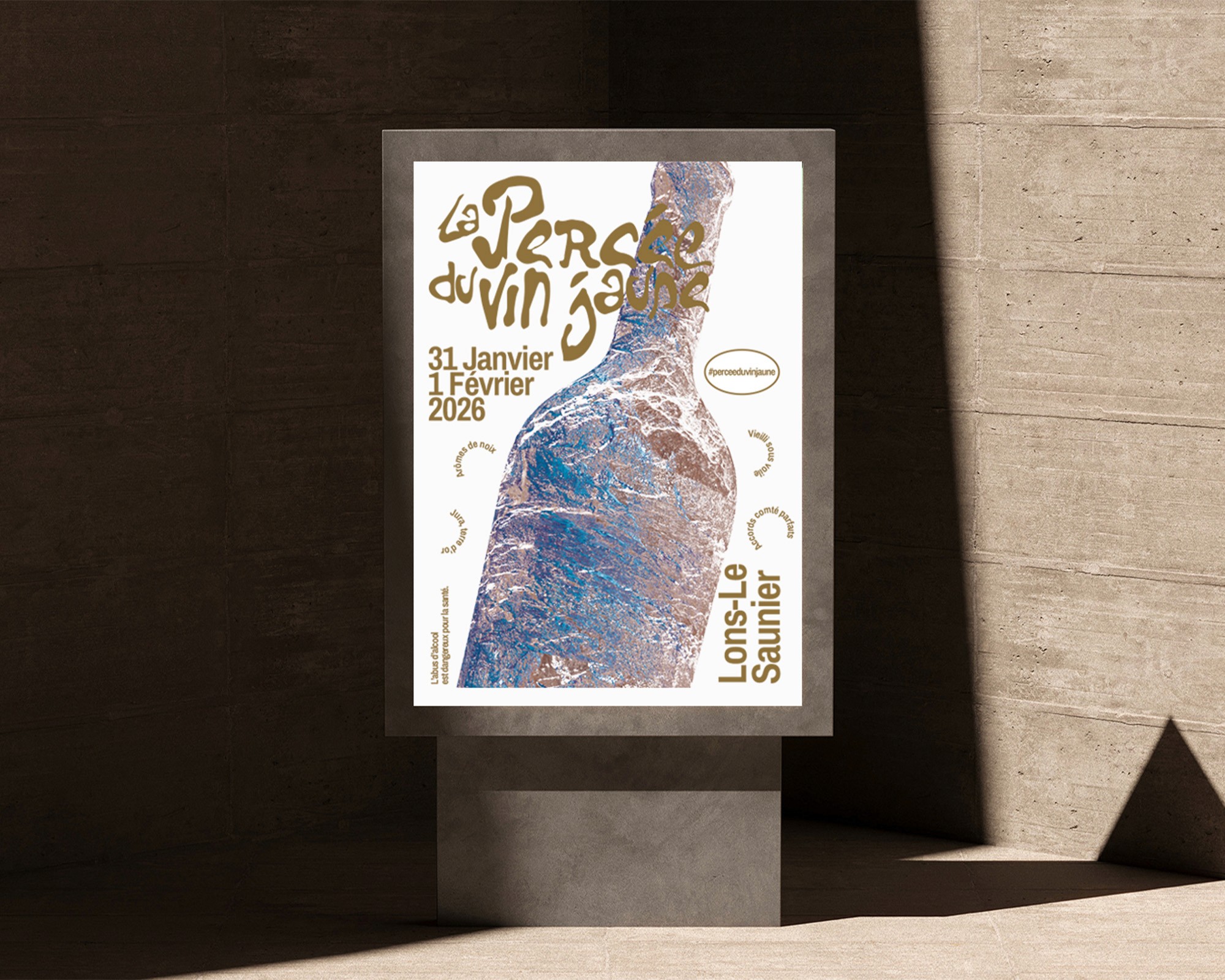 Affiche encadrée présentant l'identité visuelle 'La Percée du Vin' avec une composition mêlant typographie cursive et image photographique en tons bleus, disposée sur un mur dans un cadre noir, créant une présentation muséale du projet graphique.