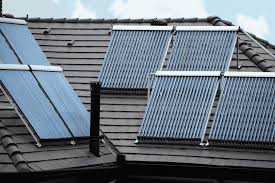 Solarthermieplatten auf einem Hausdach. Mit einer Wärmepumpe, ist die Kombination sehr energiesparend