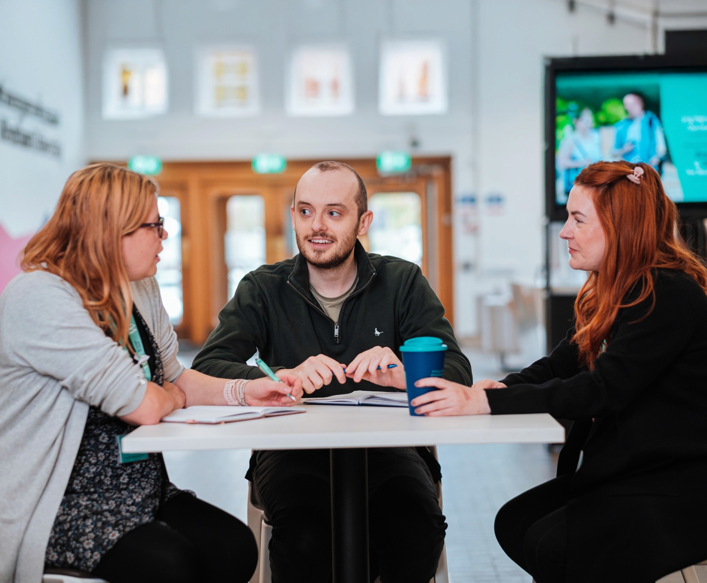 A group of students gather around a table for a chat at Bangor University.