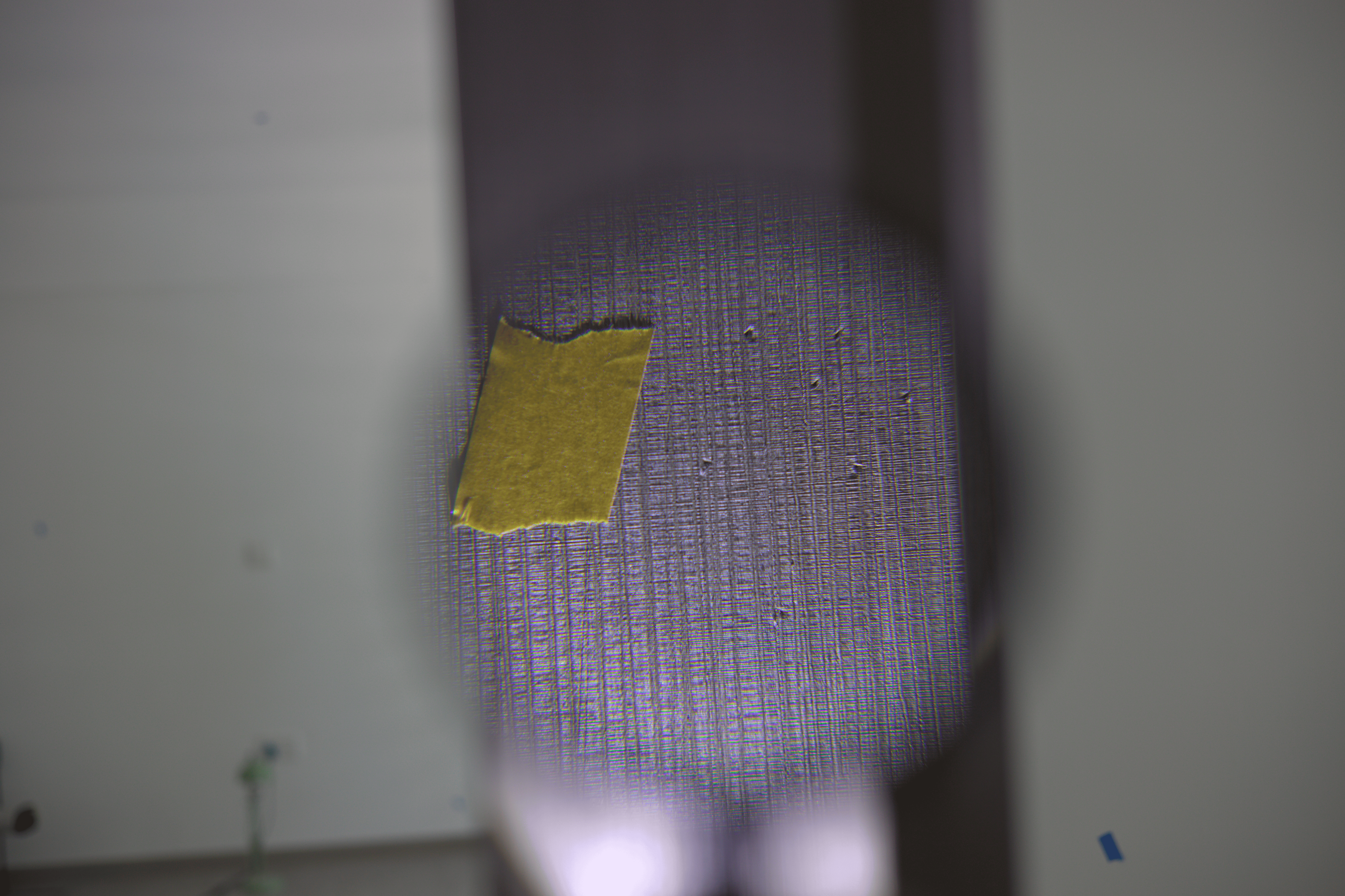 A smiling woman with her arms crossed, standing against a dark green background. She has long, dark hair.