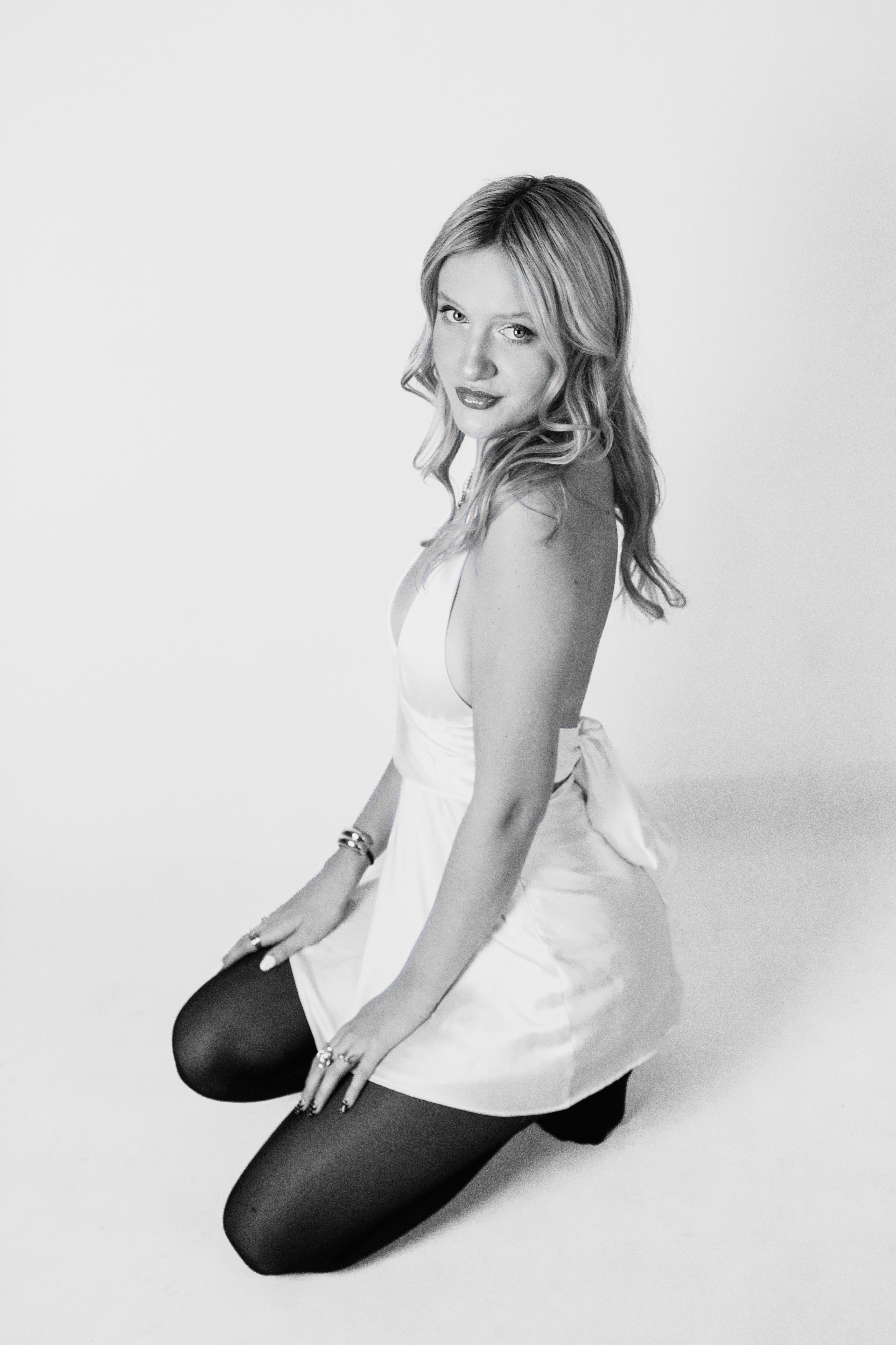 Monochrome product shot: black-capped cosmetic bottle with dynamic water splash on a clean white background.