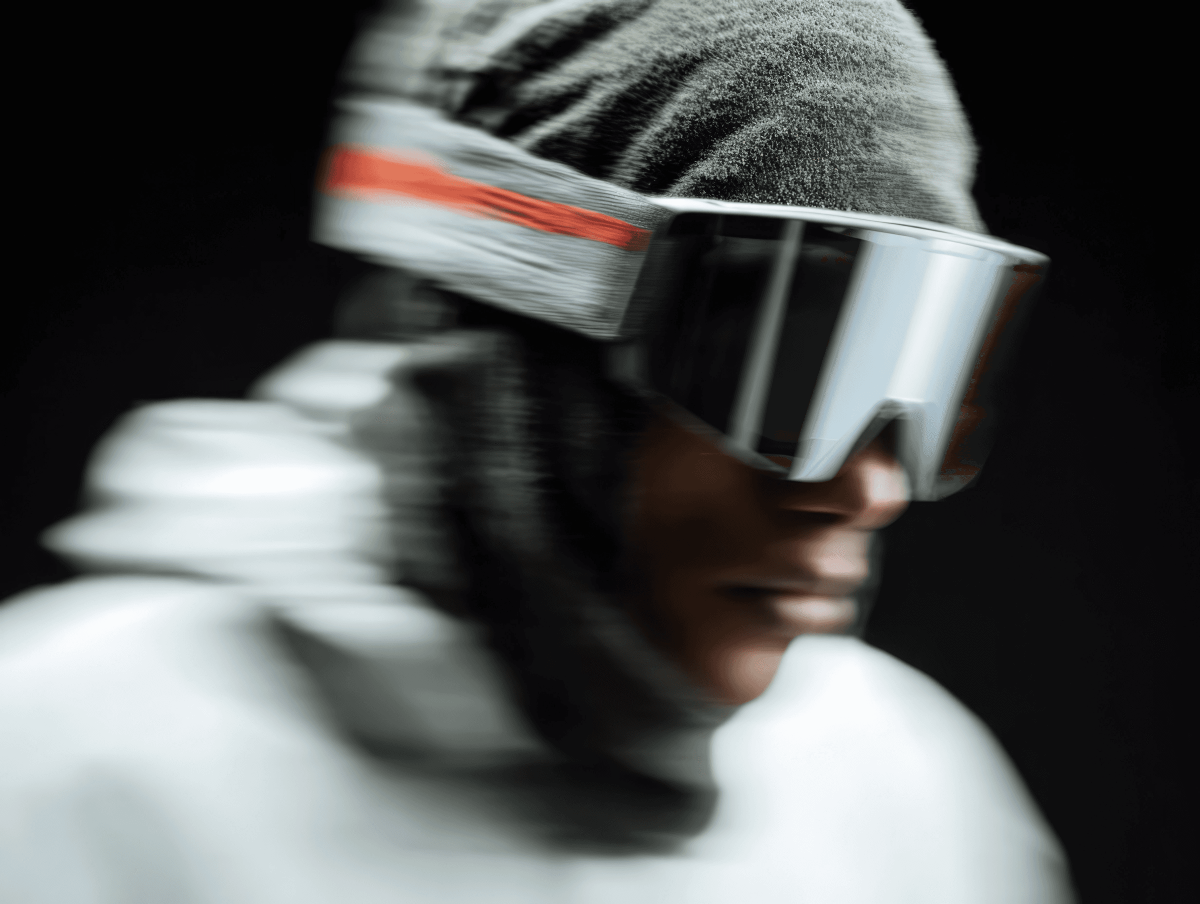 Side profile of a person in large visor goggles wearing a beanie and hoodie