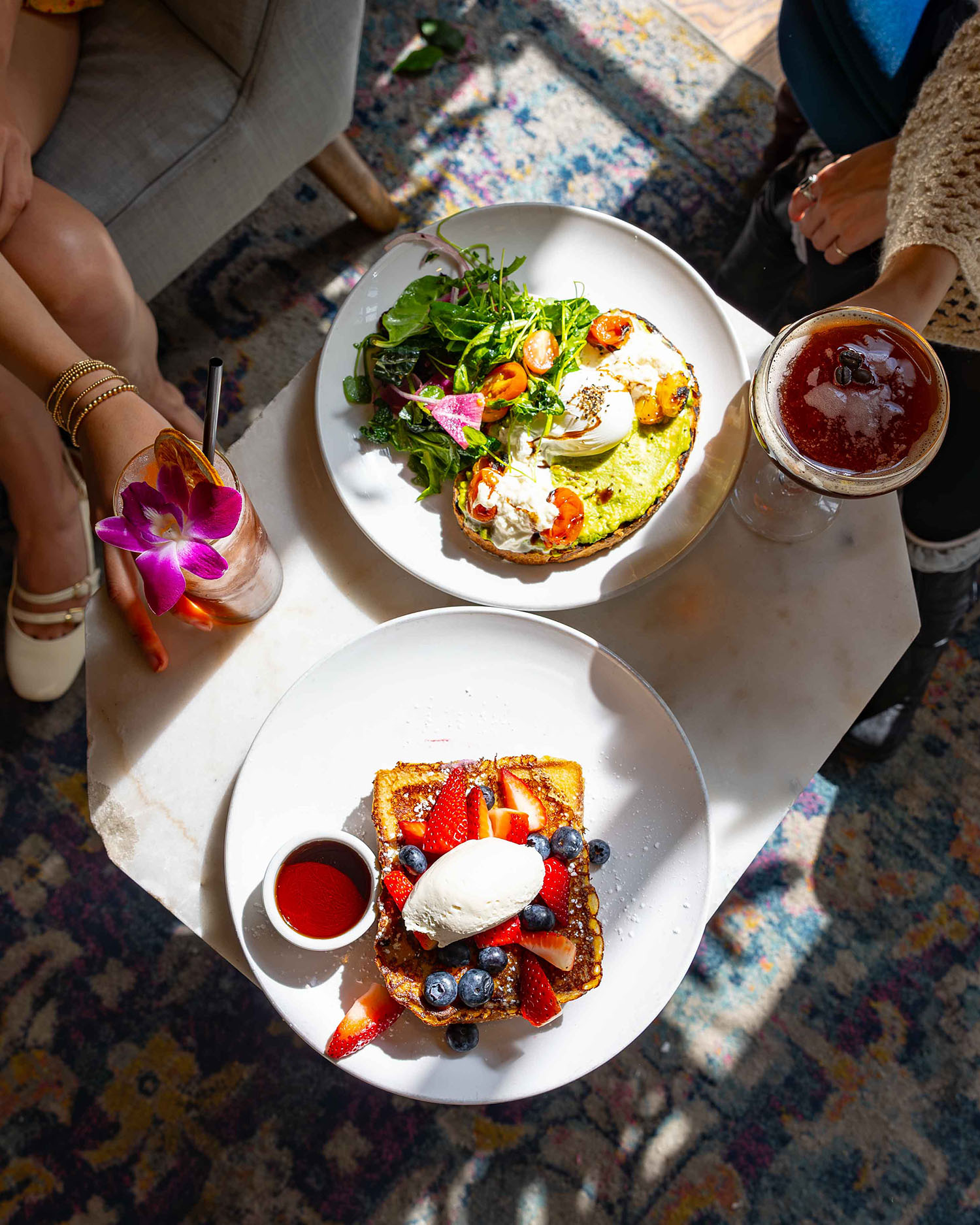 Overhead flat lay of brunch plates with waffles eggs and berries at Hubbard Inn in River North Chicago IL