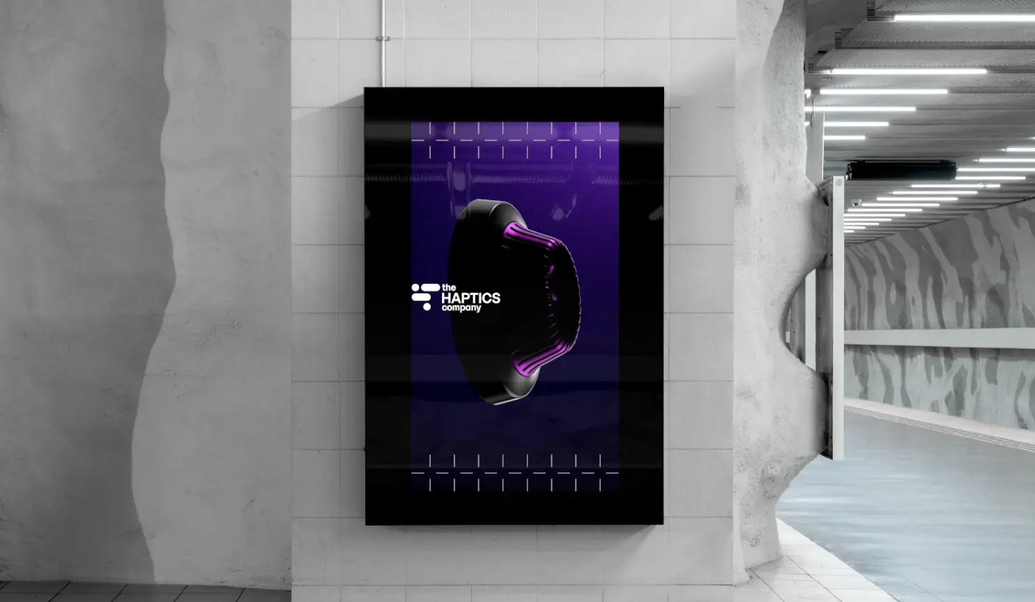 Wall-mounted display features a purple glowing haptic device and the text "the HAPTICS company" for brand identity design.