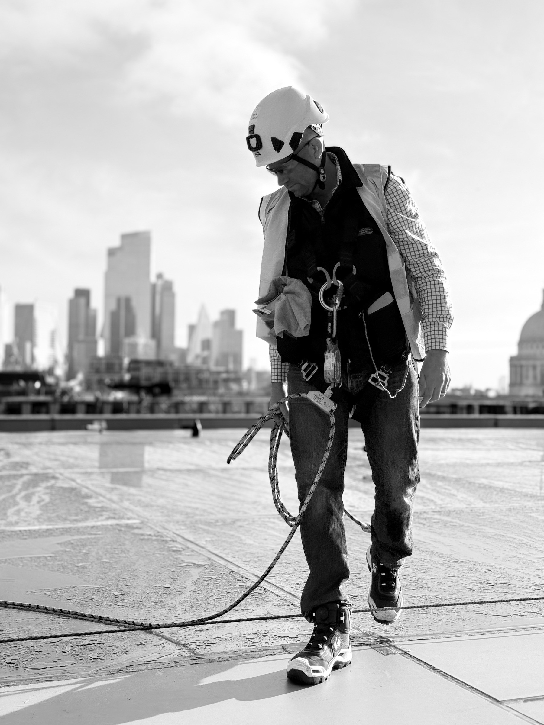 Operative in a harness on a London rooftop, shown full length
