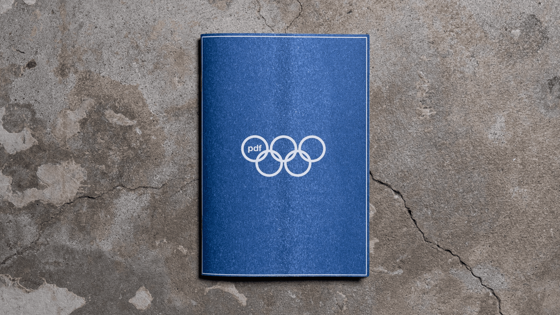 Archive PDF wide open Paris 2024 navy blue zine cover featuring the pdf Olympic five ring logo printed in white on a textured stone surface