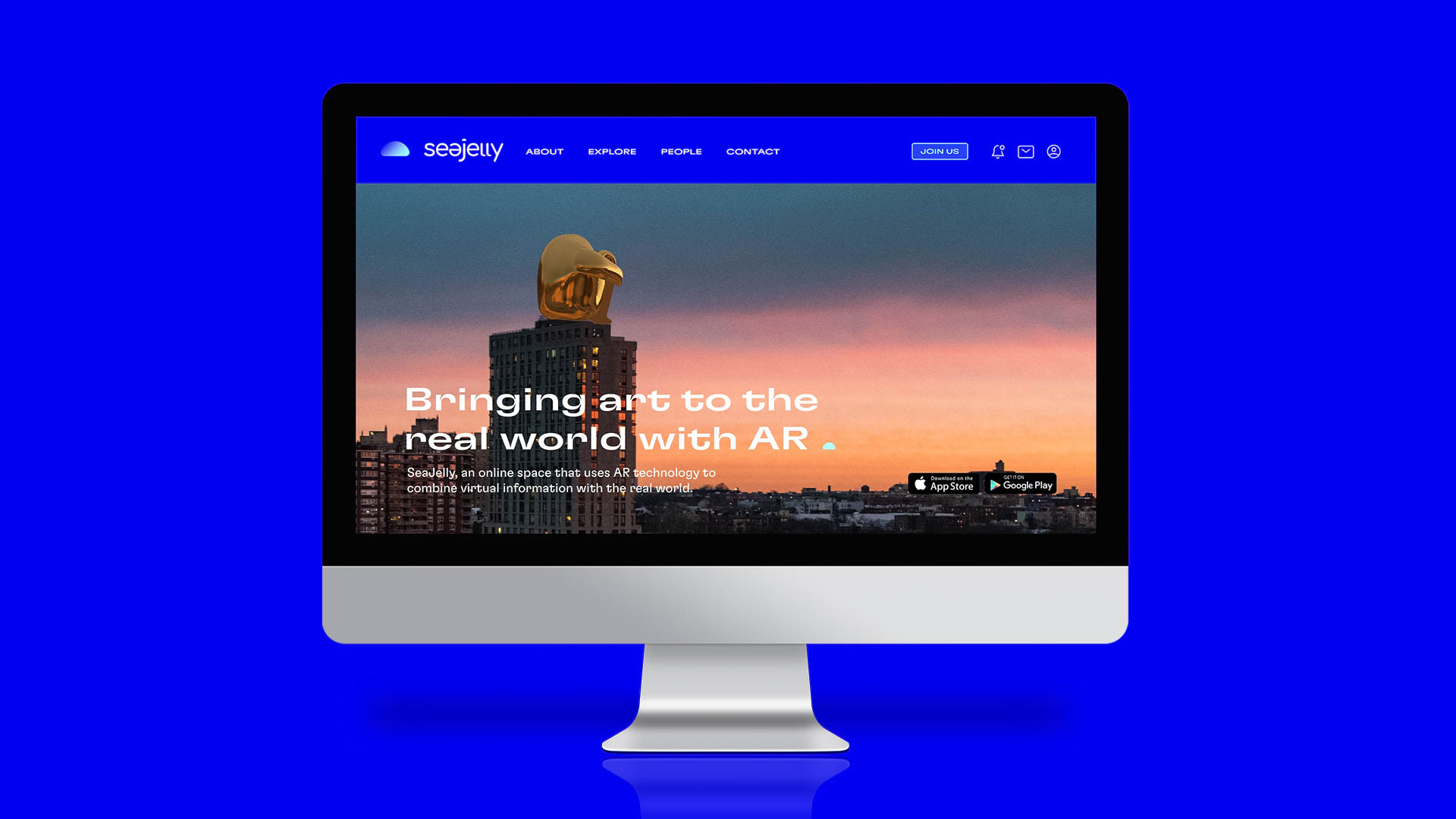 A computer screen displays a website for Seejeby, a virtual space that uses AR technology to combine virtual and real-world elements. The website features a cityscape image with a golden statue against a sunset sky. The text “Bringing art to the real world with AR” appears prominently on the page. Navigation links for “About,” “Explore,” “People,” and “Contact” are visible at the top. The background is blue, and the screen is mounted on a silver stand.