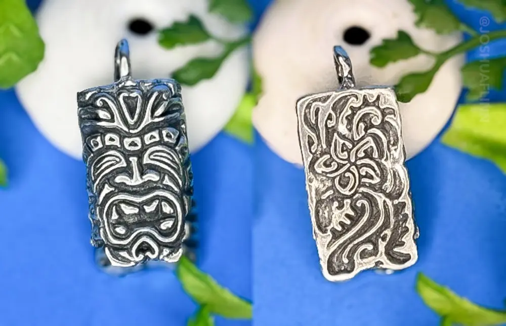 photograph of a cast silver pendant of a polynesian tiki