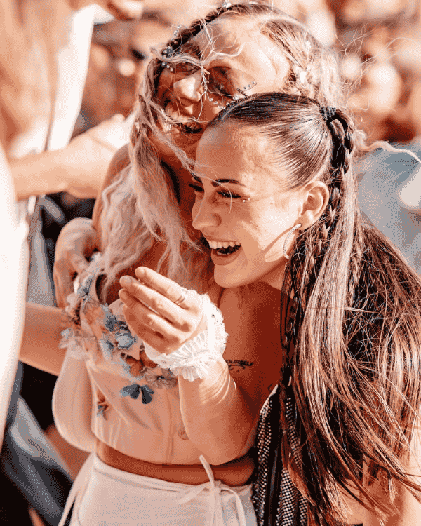 Two friends laughing at an outdoor event