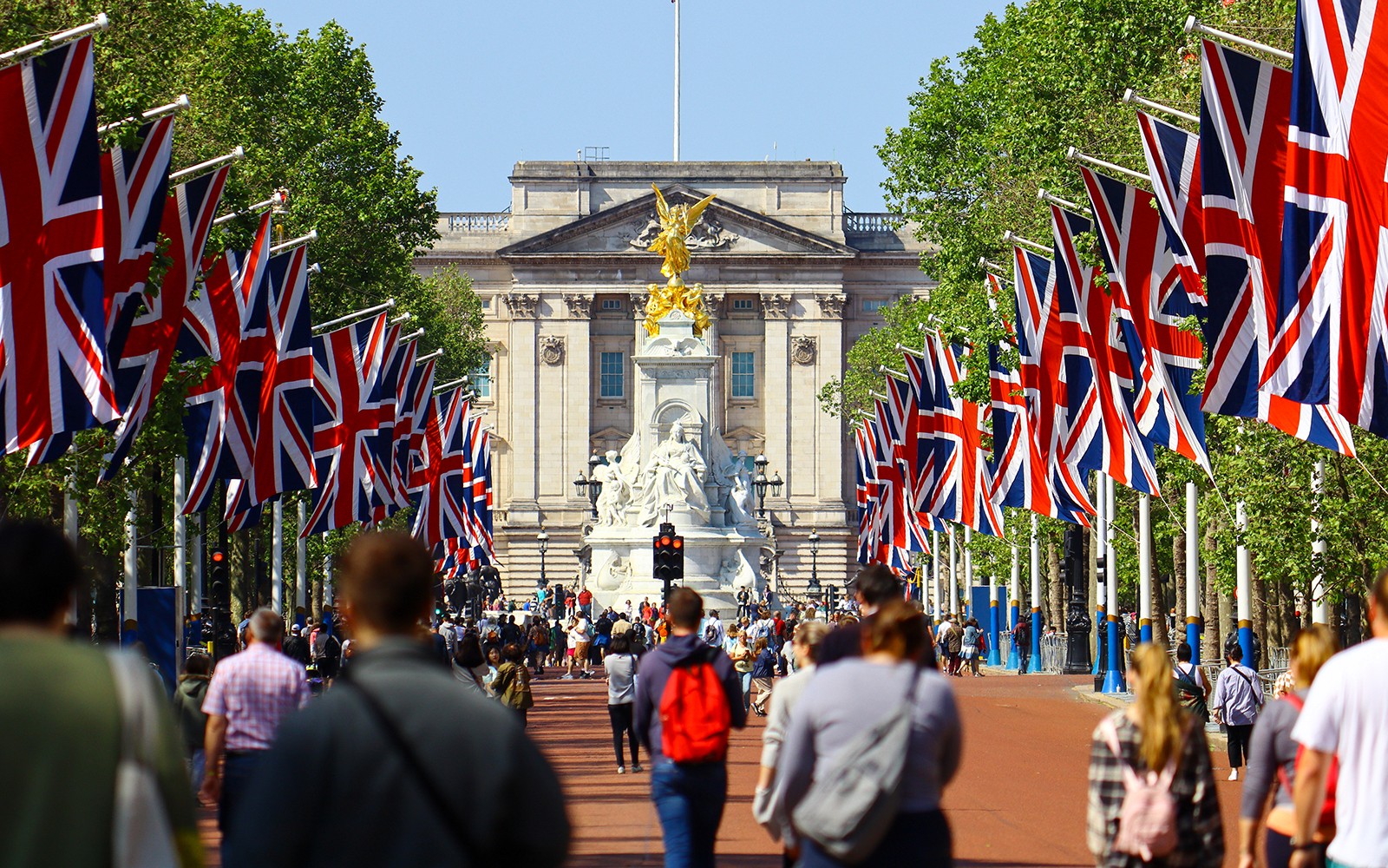 Tourists walking towards Buckingham Palace on Westminster tour, London.