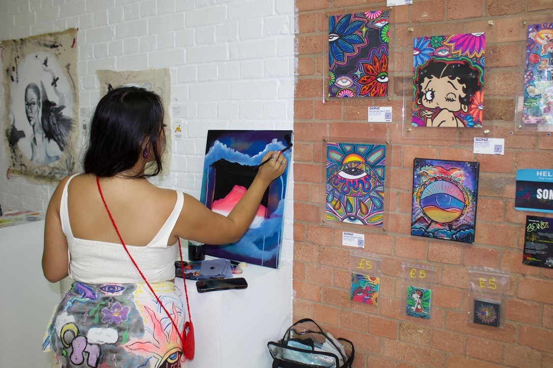 Painting in progress alongside installed artworks