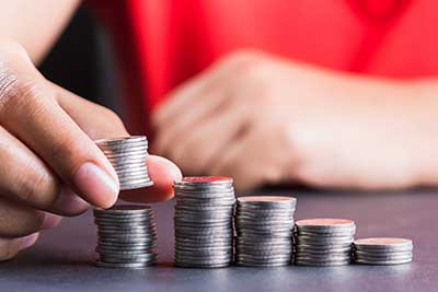 Hand taking away coins from top of stack