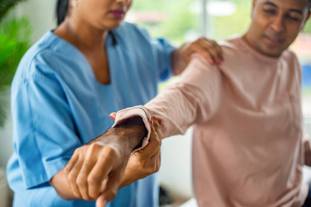 Physiotherapist performing assisted arm mobility therapy to improve shoulder and elbow movement.