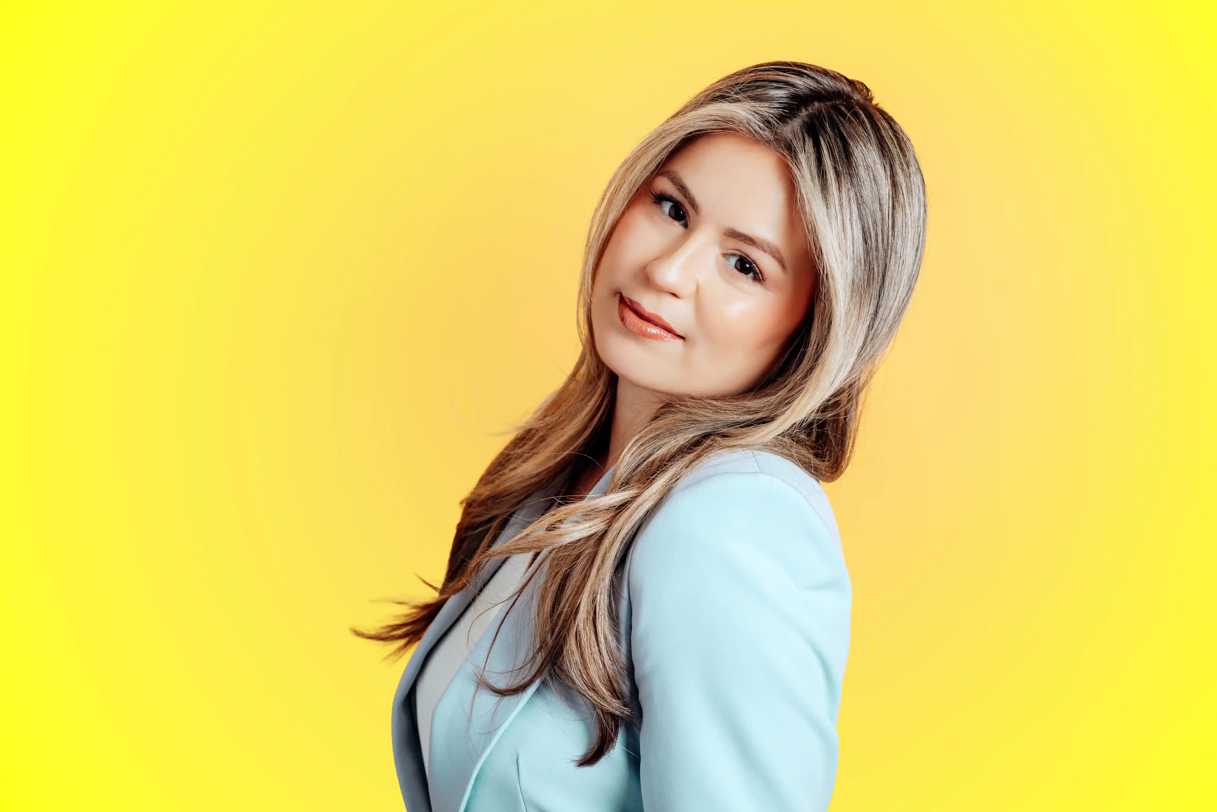 Personality portrait wearing light blue blazer on a yellow background for Tampa personal branding studio session