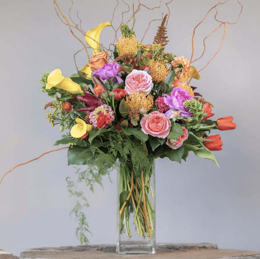 A table with plates , glasses , and flowers on it.