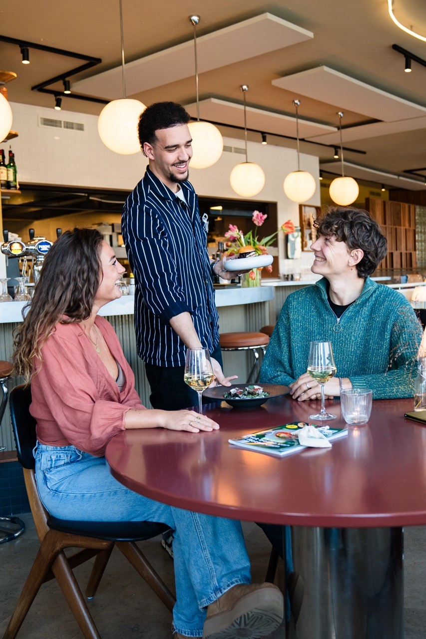 waiter bringing the food to the table at a restaurant