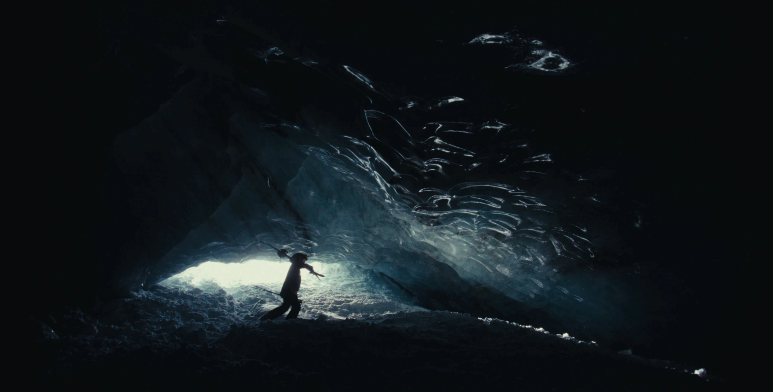A person stands in a sandstone cave.