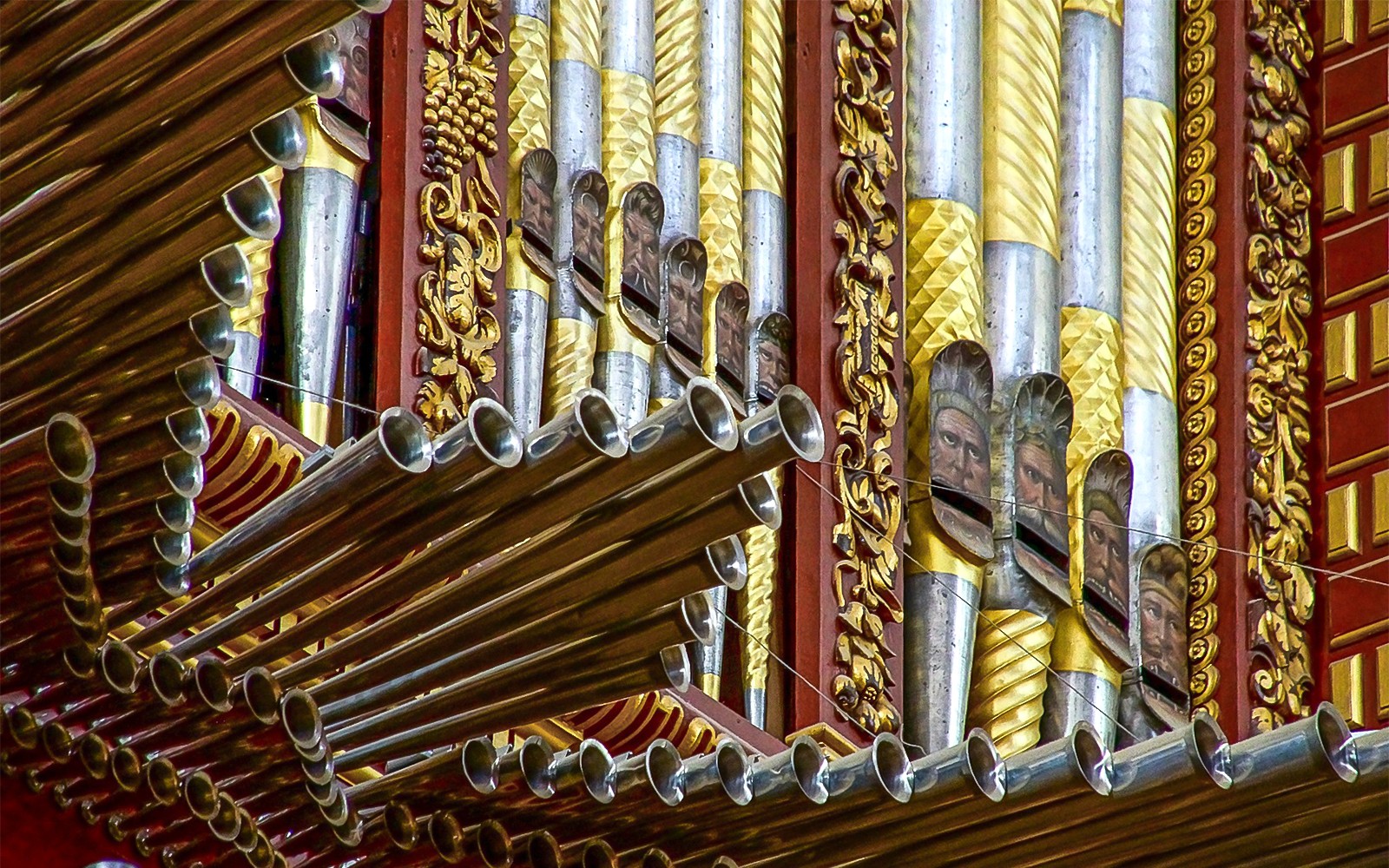 Tubos de órgano ornamentados dentro de la Mezquita-Catedral de Córdoba, con intrincados diseños en oro y plata.