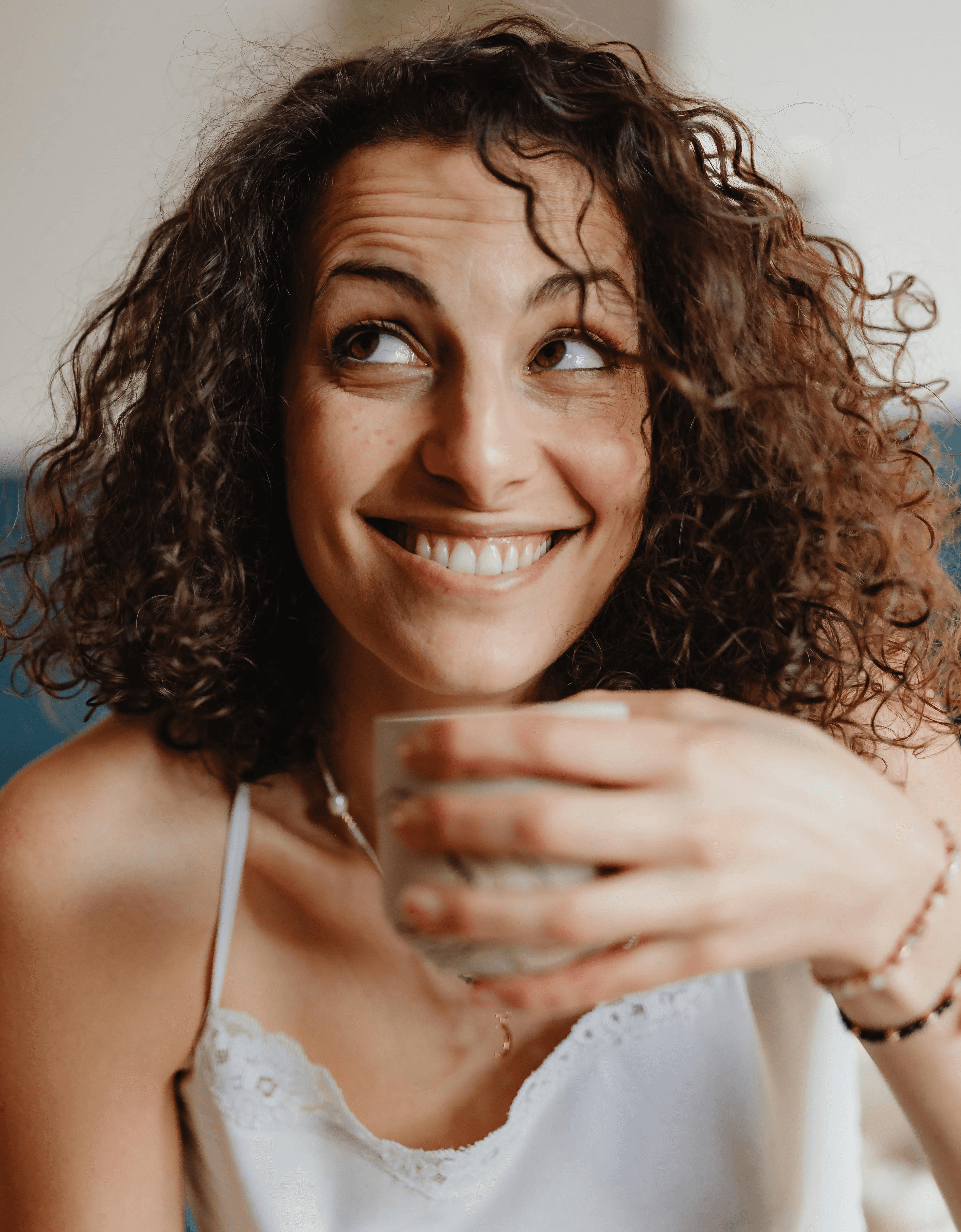 A smiling young man with crossed arms, wearing a plaid shirt and white t-shirt, poses against a dark background.