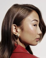 A model with straight brown hair wearing a red top.