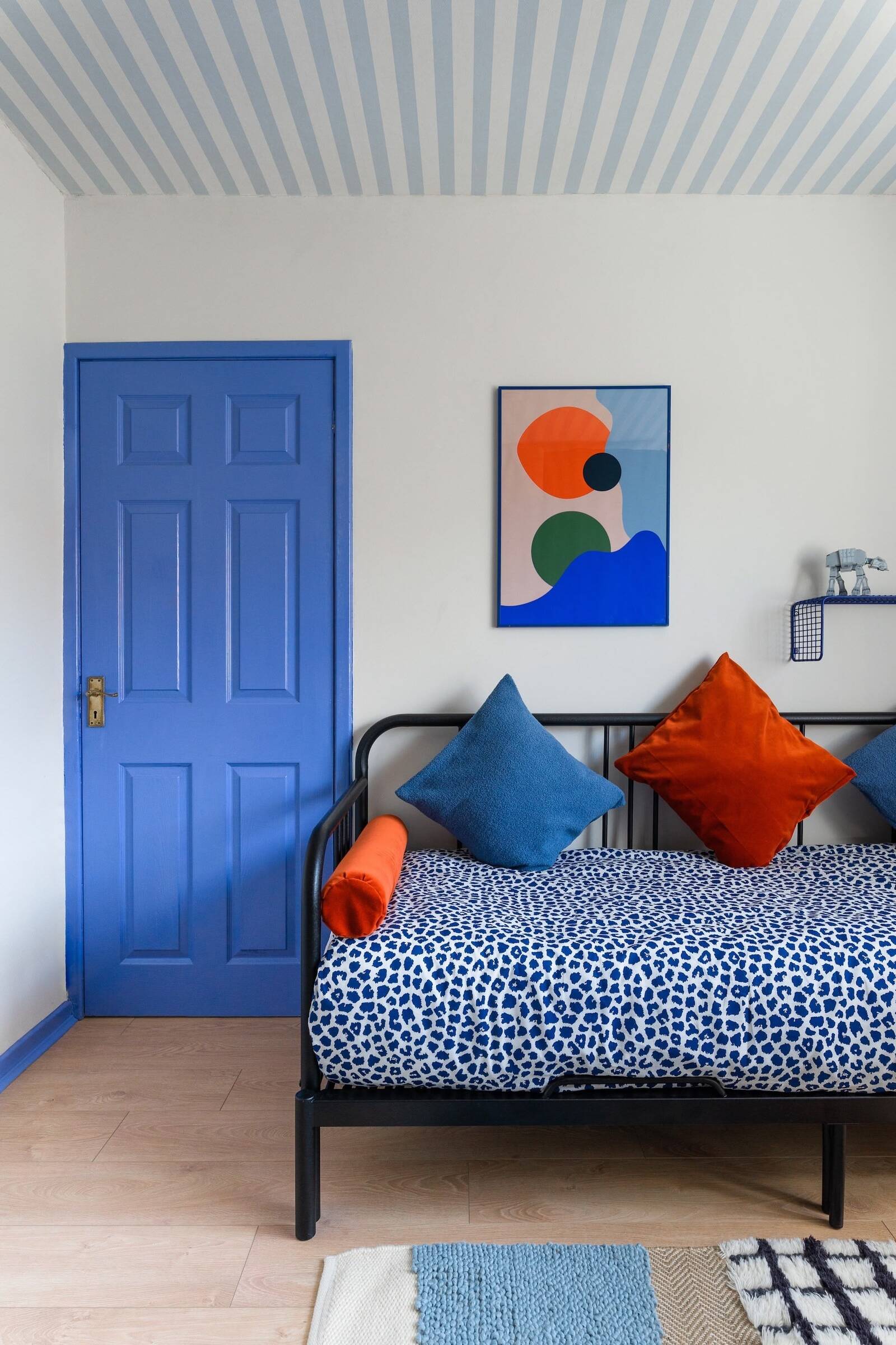 Cosmic-themed blue and neutral teen bedroom with trundle bed transforming into sofa, hidden Lego storage, vibrant playful interiors, Atelier Akuko