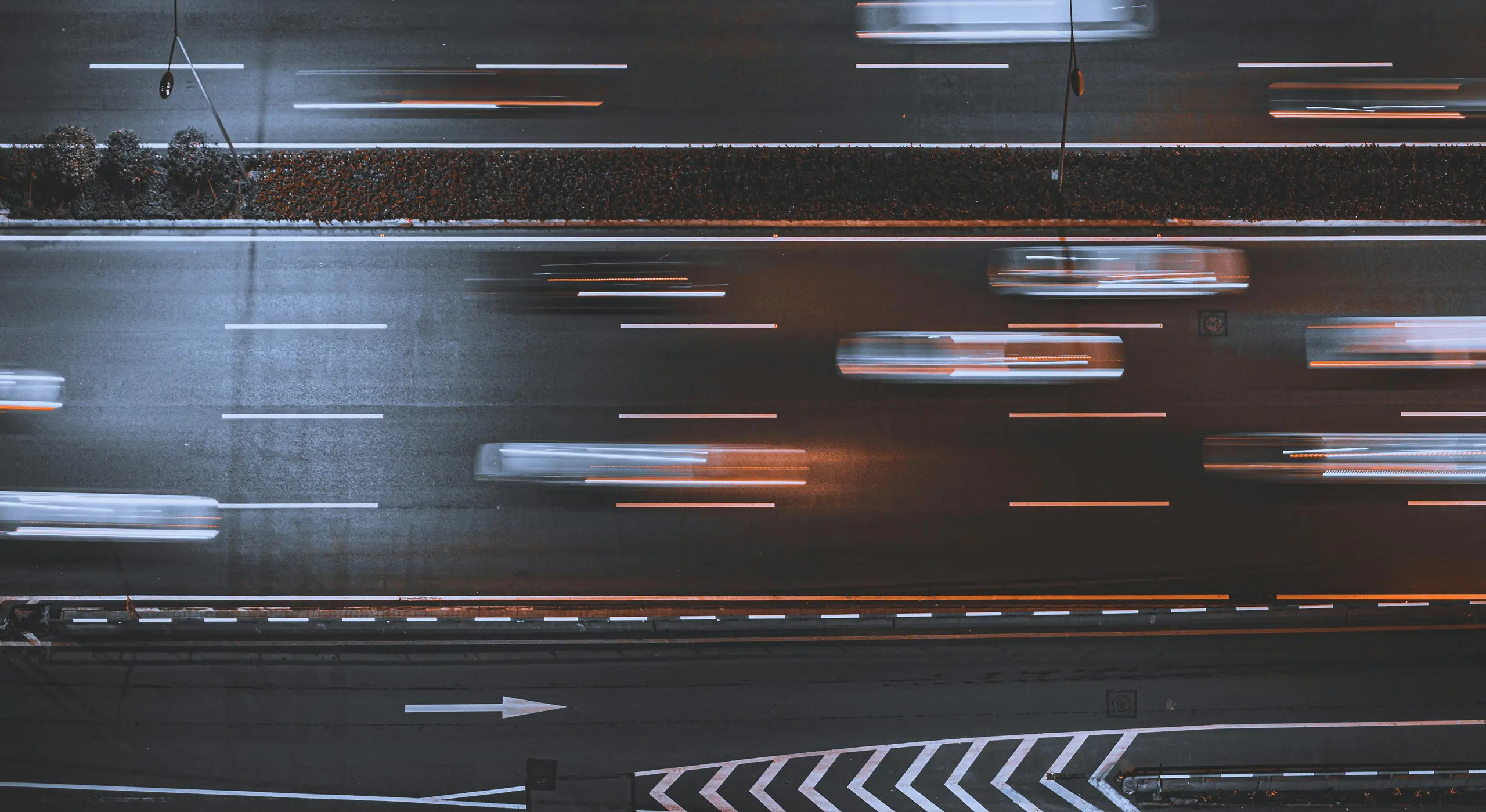 Top-down view of blurred car light trails on a highway.