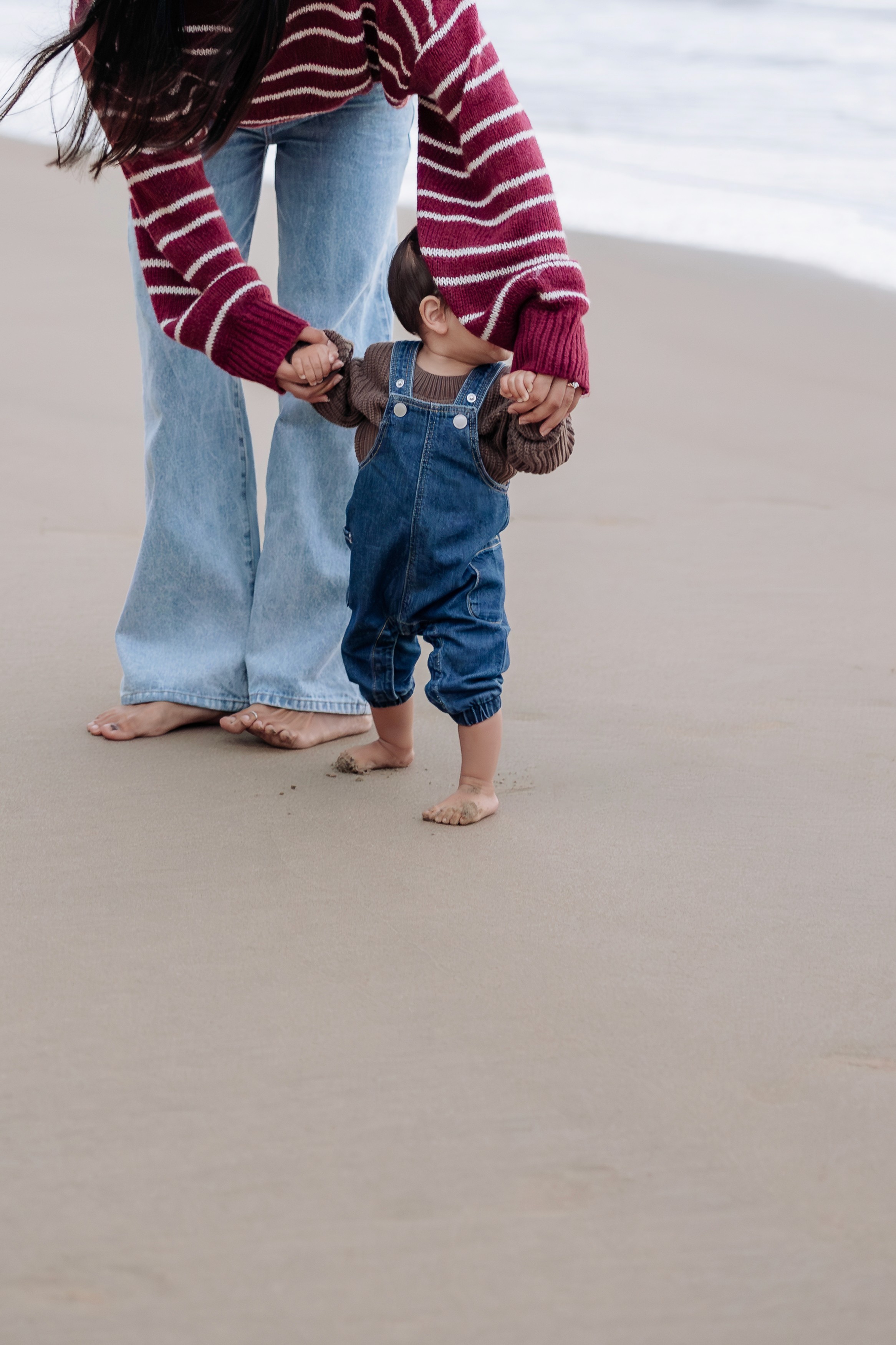 Relaxed winter family portraits in Mackay featuring neutral tones, oversized knits, and soft coastal light