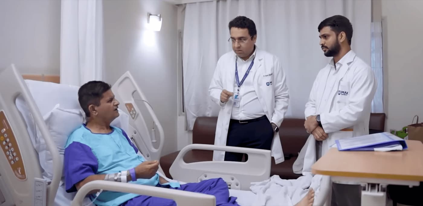 डॉ. Tushar और Manish मरीज के बिस्तर के पास खड़े हैं, व्यक्तिगत मार्गदर्शन प्रदान कर रहे हैं और उनकी रिकवरी की जांच कर रहे हैं।
