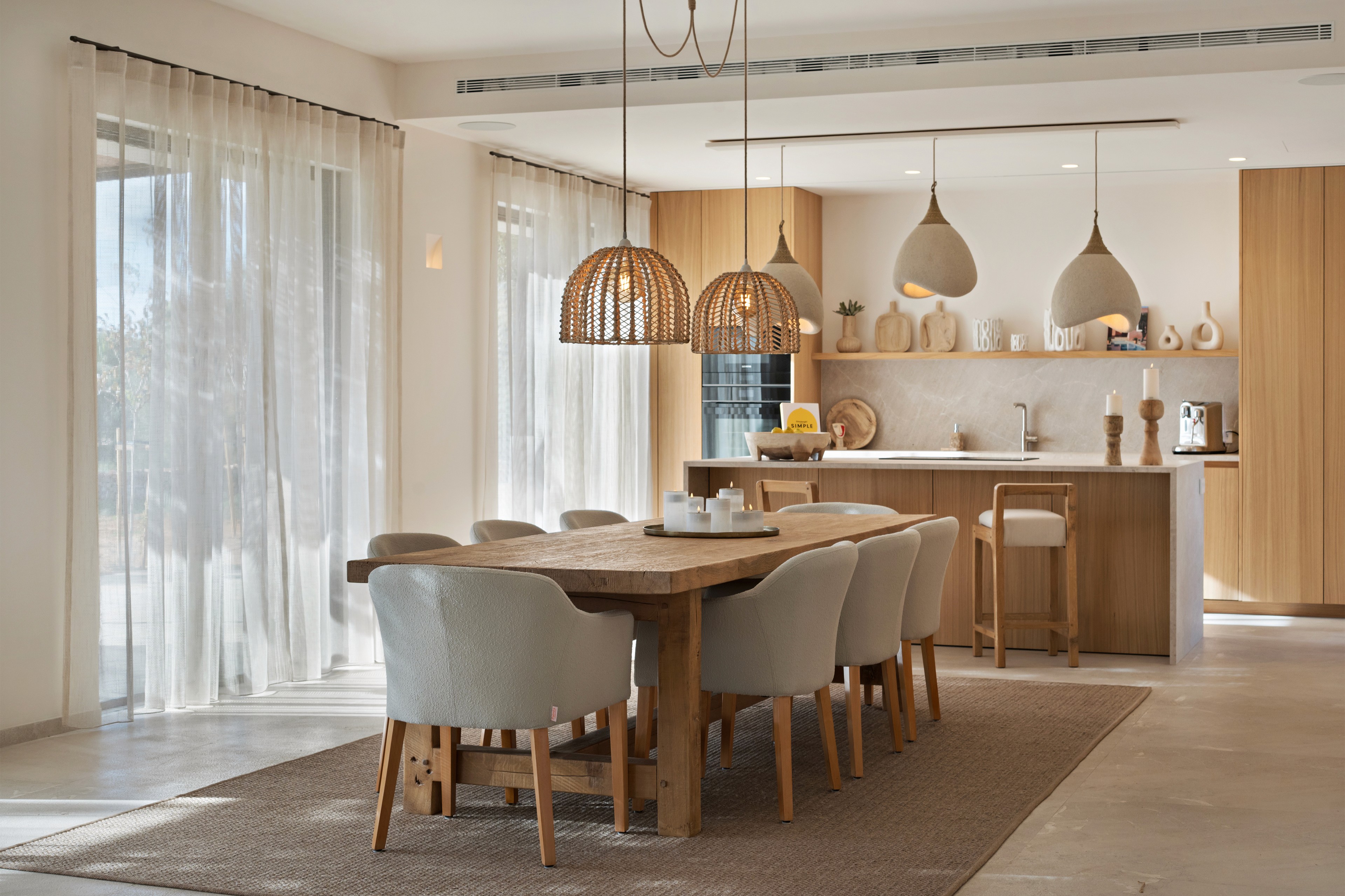 Essbereich der Finca in Ses Salines mit Holztisch, Designleuchten und offener Küche im modernen Mallorca Stil