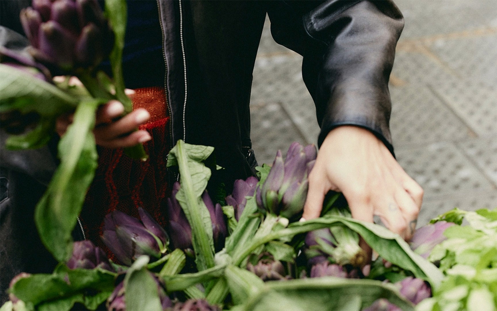 a women picking up vegetables from a farm shop